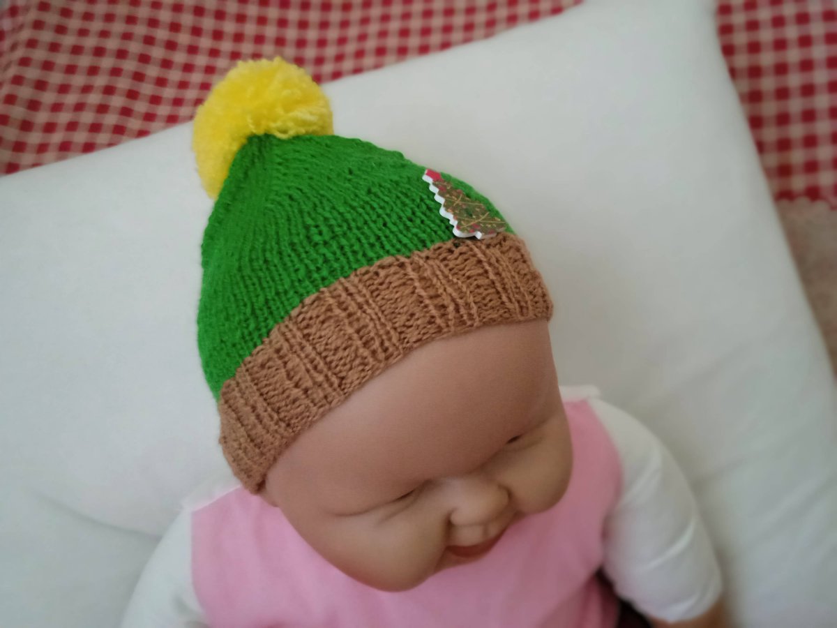 Hnědozelená čepička s vánočním knoflíkem a žlutou bambulí 