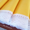 Běhoun ve žlutém provedení s motivem bílých puntíků, lemovaný bílou krajkou šíře 45 mm