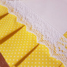 Závěs na troubu ve žlutém provedení s motivem bílých puntíků, lemovaný bílou krajkou šíře 45 mm