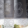 Záclonka v šedém provedení s motivem bílých srdíček, lemovaná bílou krajkou šíře 45 mm, 20 mm