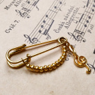 Ozdobný spínací špendlík, zlatý houslový klíč