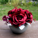 Kytice vínových růží ve starostříbrné keramické kouli na stůl