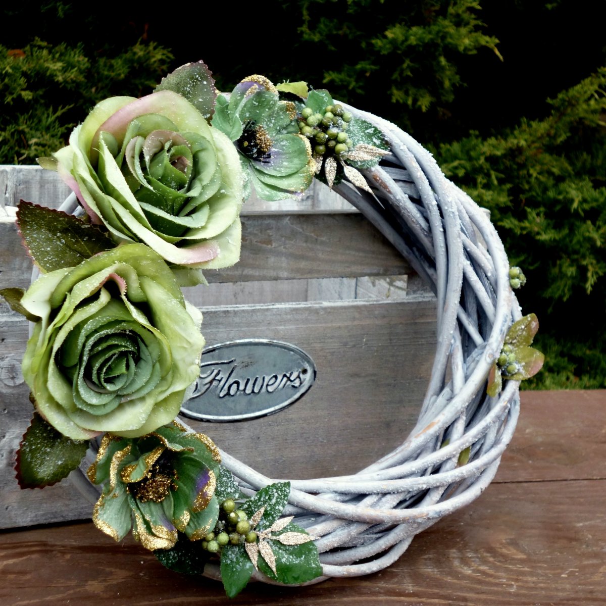 Zasněžený věnec na dveře se zelenými růžemi a čemeřicemi