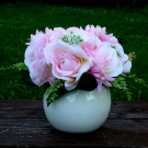 Kytice růžových růží v bílé lesklé keramické kouli