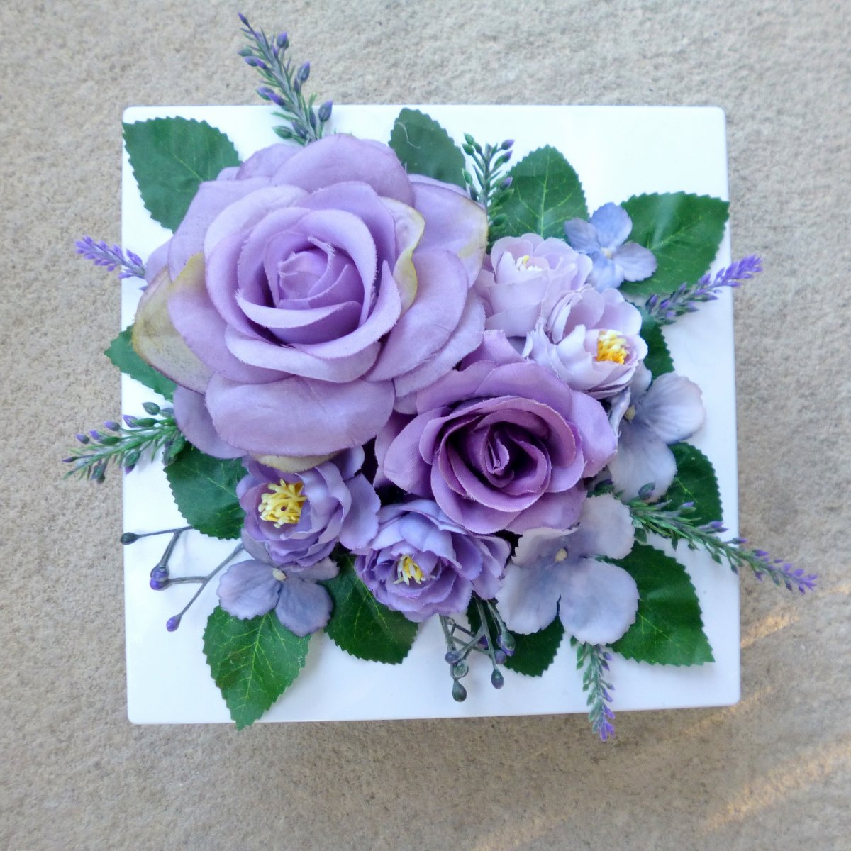 Aranžmá s růžemi v šeříkových odstínech na bílé misce