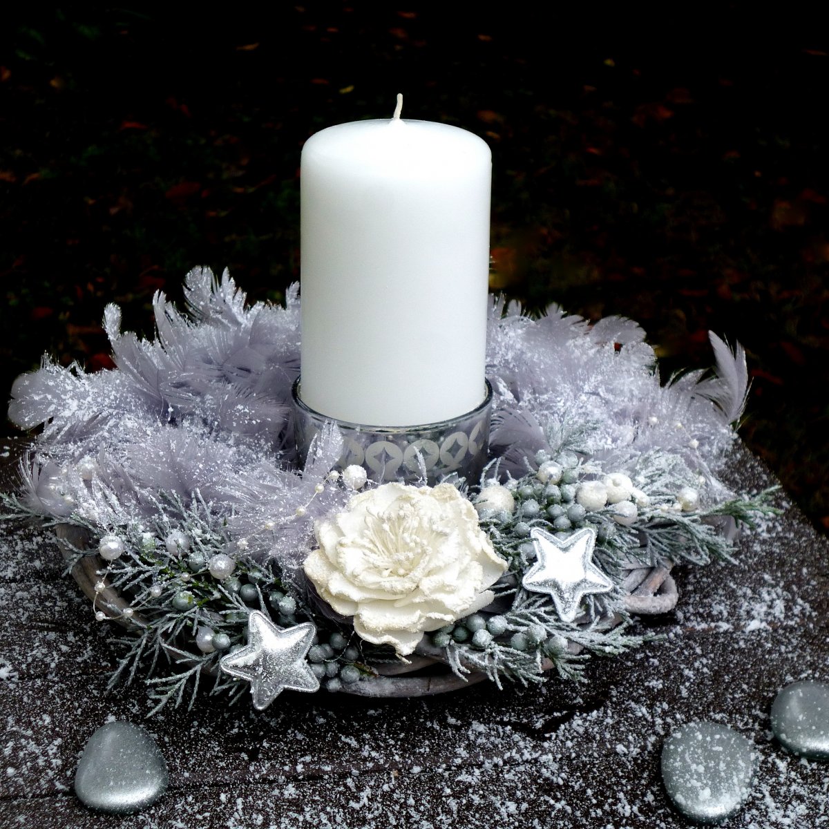 Zasněžený vánoční svícen s bílou svící a peříčky
