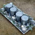 Adventní svícen se stříbrnými ojíněnými svícemi na metalickém tácu