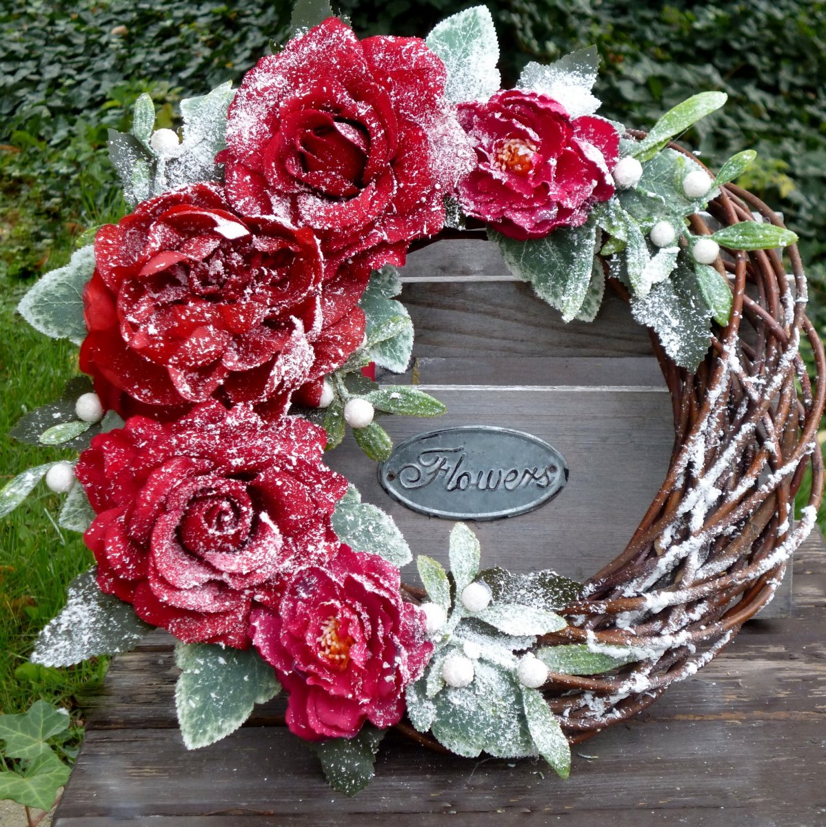 Zasněžený věnec s červenými růžemi a jmelím