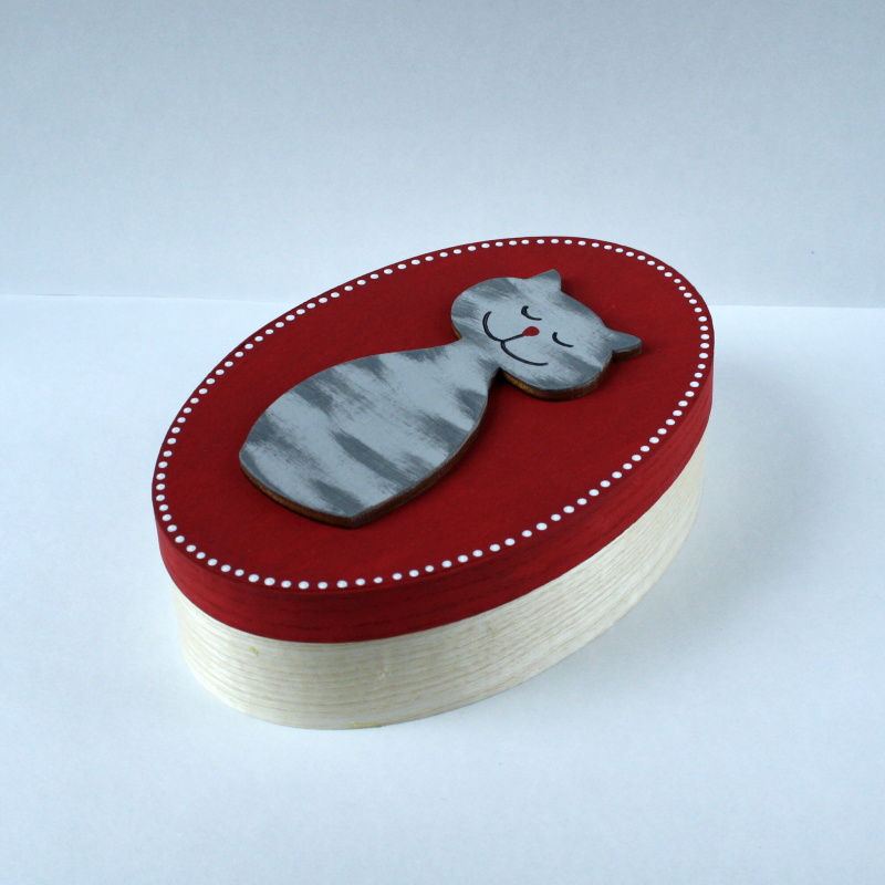 Oválná krabička se spící kočkou