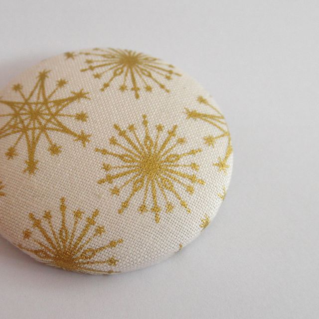 brož se zlatými vločkami